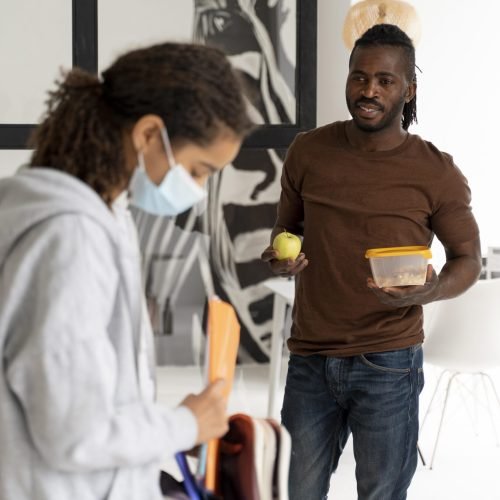 man-giving-lunch-box-his-daughter